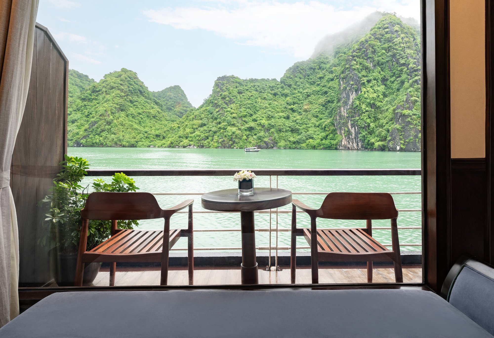 Ban công riêng của cabin với bàn ghế nhìn ra núi đá