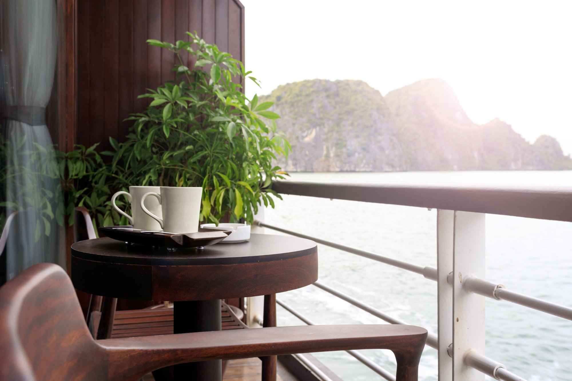 Tách cà phê trên bàn ban công cabin nhìn ra vịnh