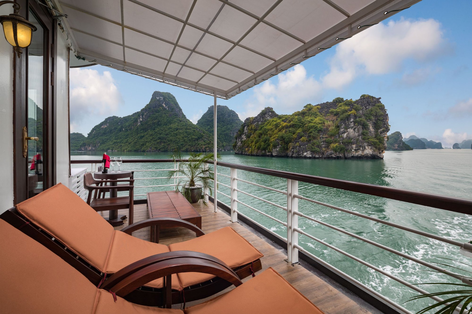 Ban công cabin du thuyền với ghế nằm nhìn ra núi đá