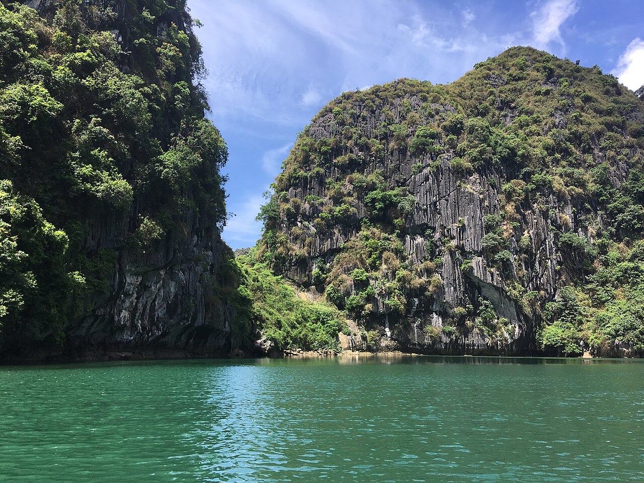 Cruise boat on Ha Long Bay amid limestone mountains