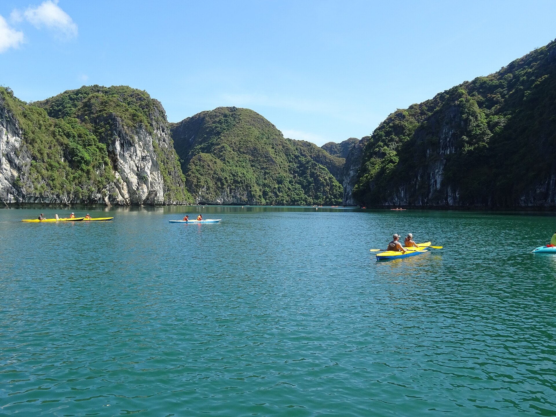Du khách chèo kayak trong áng nước giữa núi đá
