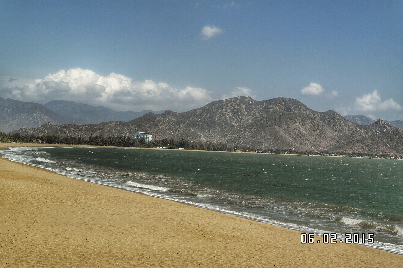 Bãi biển Ninh Chữ với cát dài và núi phía xa